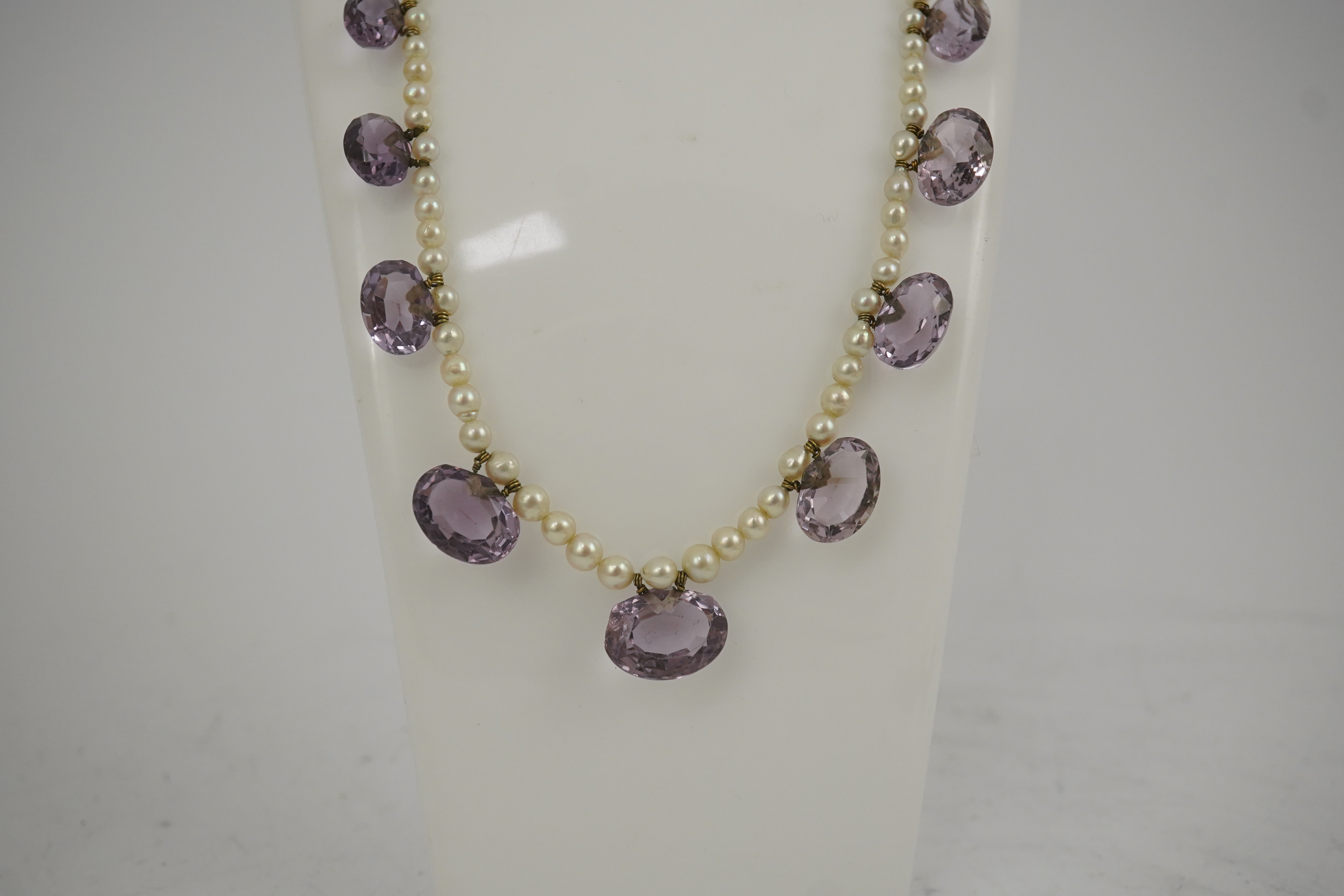 A 19th century pearl and graduated fifteen stone oval cut amethyst set drop necklace, with a gold barrel shaped clasp